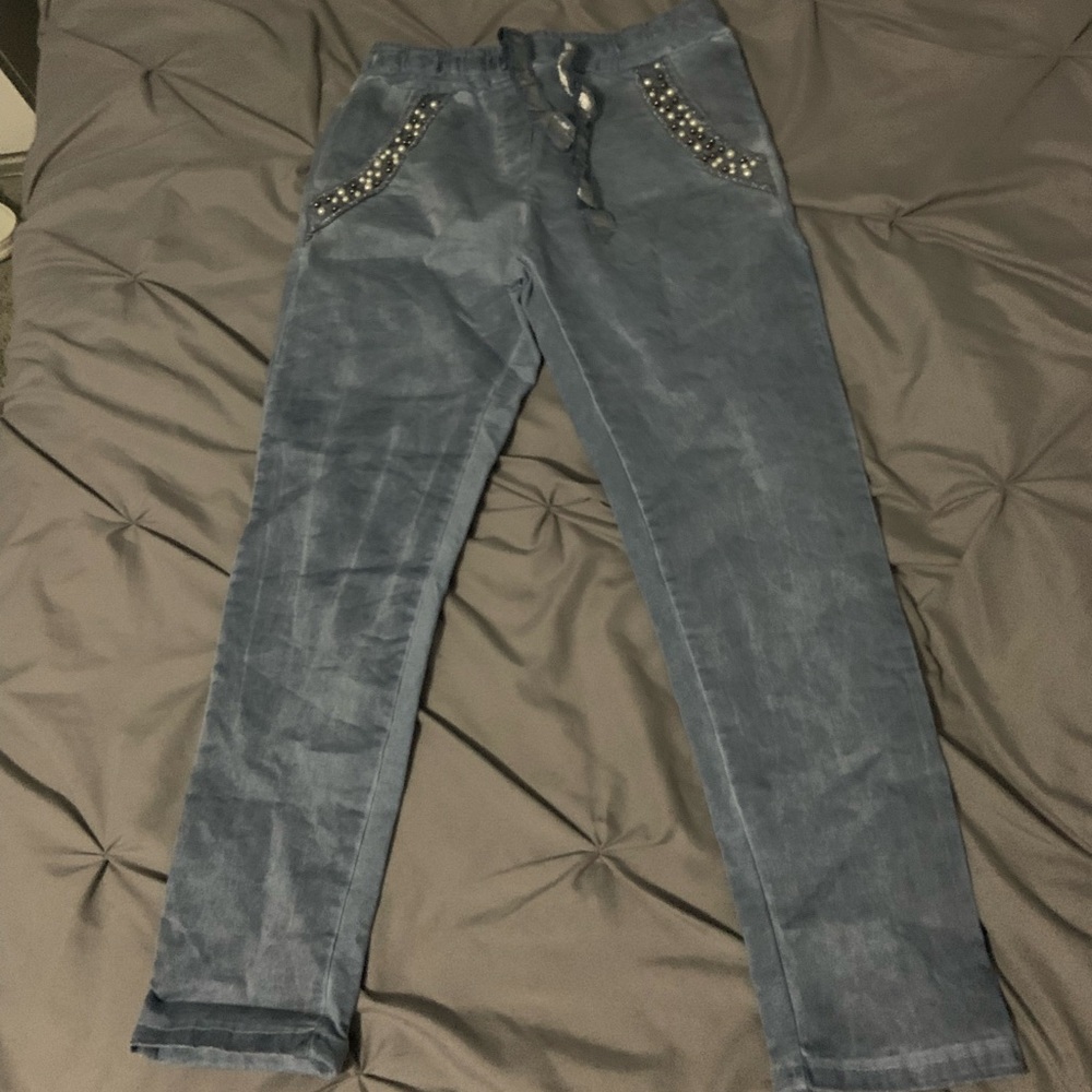 Looks like jeans with pretty pearl details outside pocket
Made in Italy